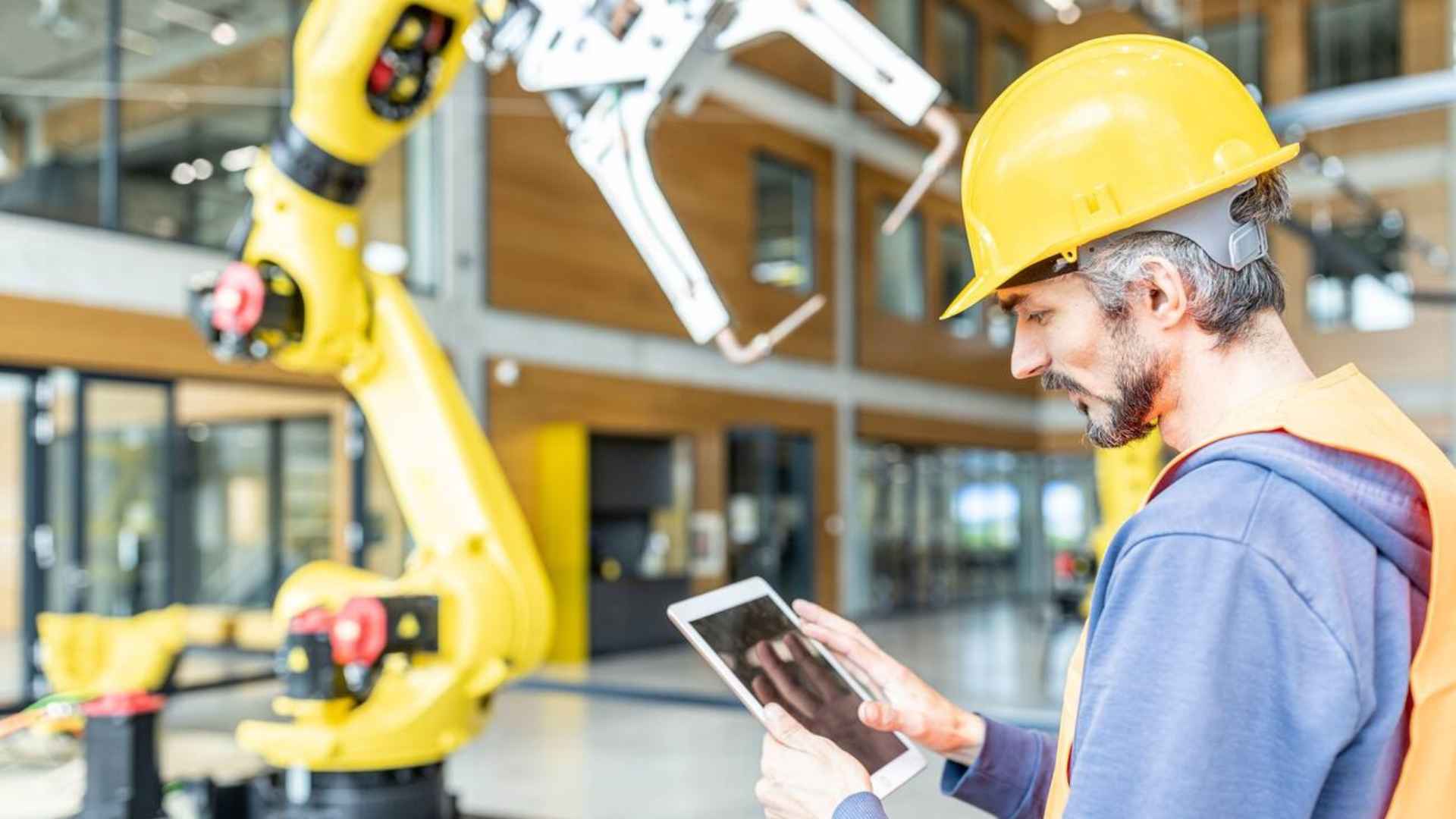 a man wearing a hard hat and holding a tablet